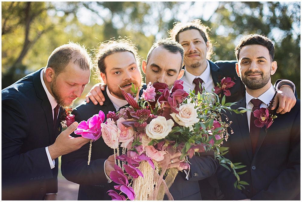 Groomsmen sniffing bouquets