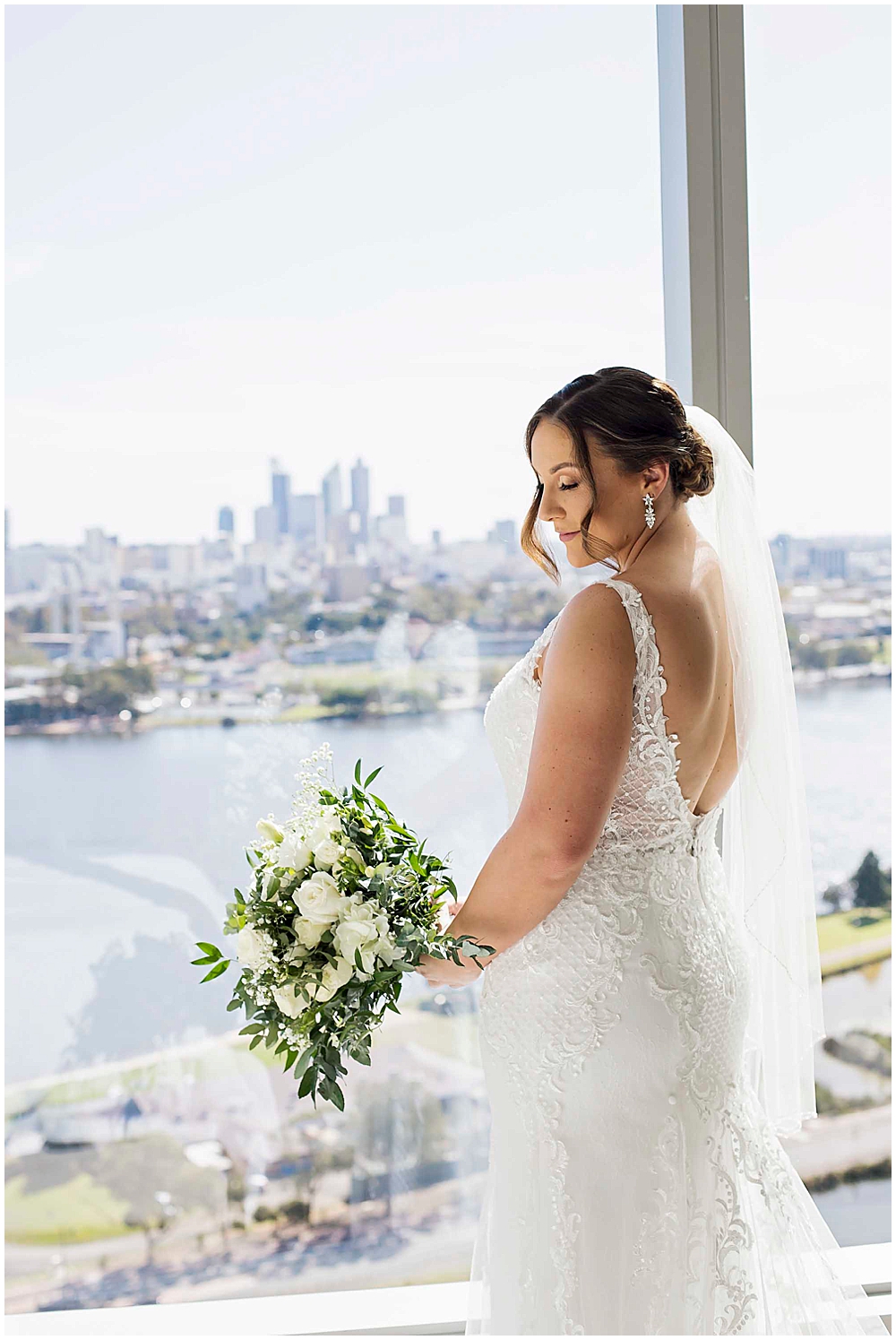 Bride standing at window of Crown Towers