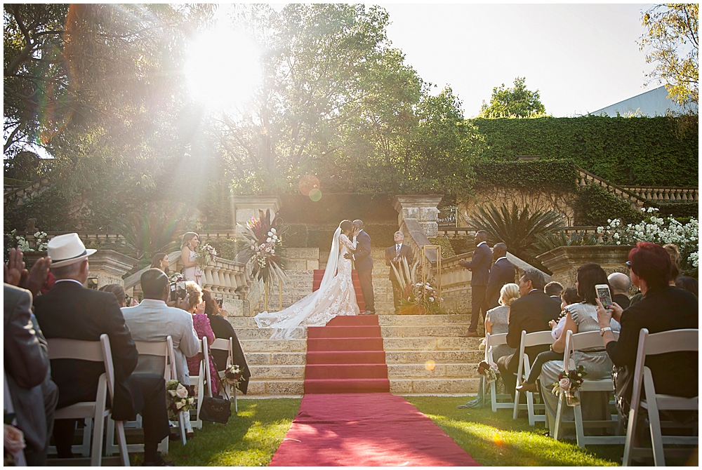 bride and groom on staircase at Caversham House with sun