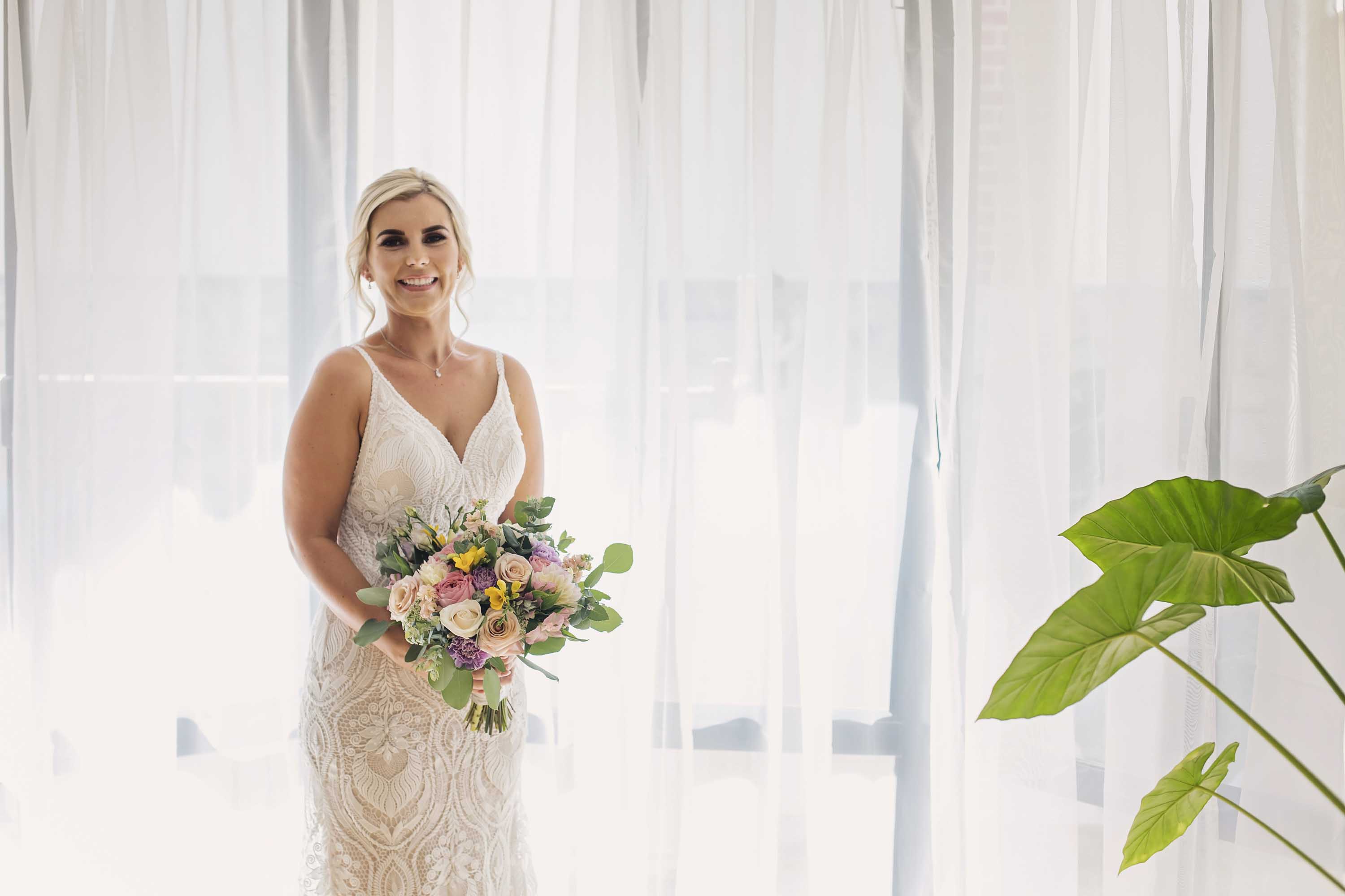 Bride standing in front of window